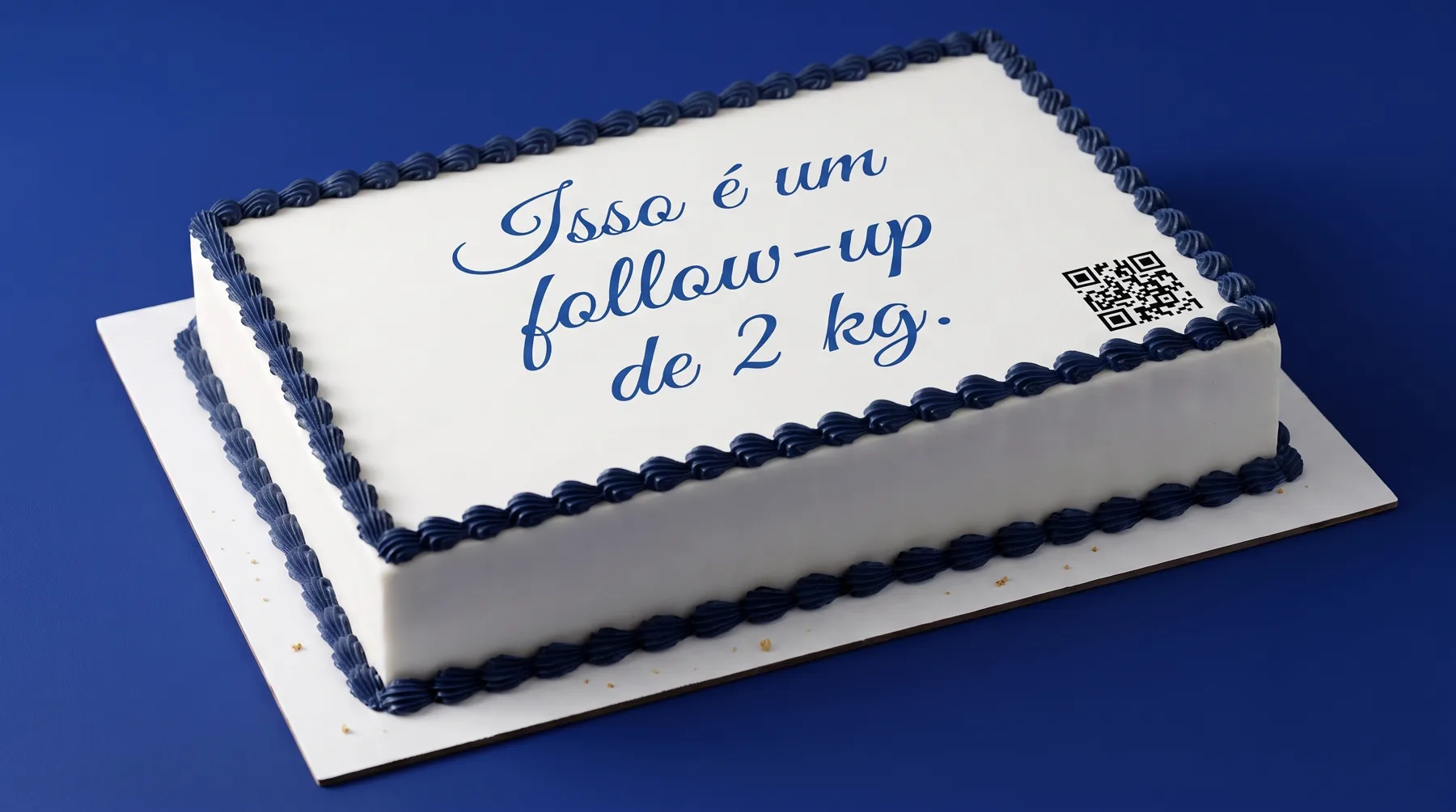 Bolo branco com borda de merengue azul e a mensagem escrita em glacê cursivo: Isso é um follow-up de 2 kg. QR no canto.