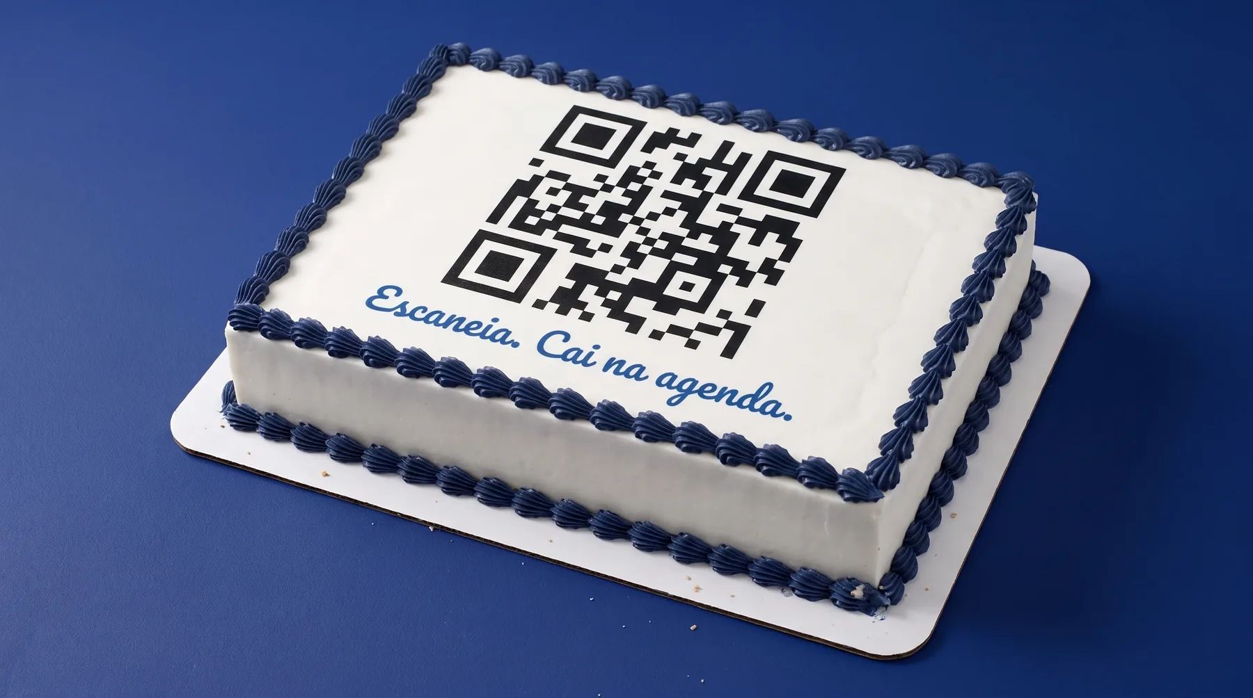 Bolo com um QR code gigante impresso no topo e a frase em glacê: Escaneia. Cai na agenda.